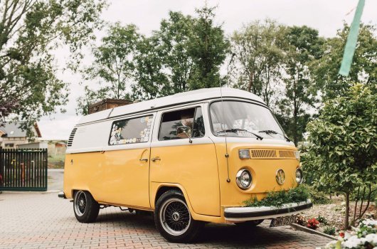 „Nowoczesny biały bus 9-osobowy zaparkowany na tle gór Beskidów, gotowy do wynajmu w wypożyczalni samochodów w gminie Ciściesz, idealny na rodzinne i grupowe wyjazdy.”